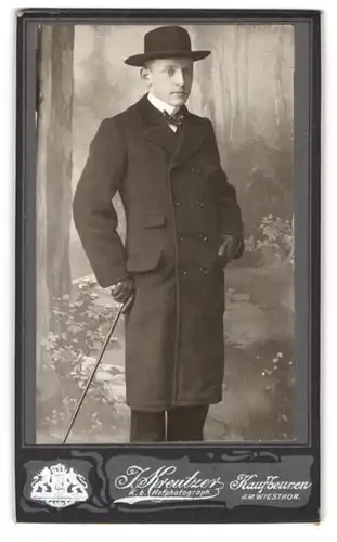 Fotografie J. Kreutzer, Kaufbeuren, Am Wiesthor, Portrait junger Mann in feinen Mantel posiert mit Stock und Hut