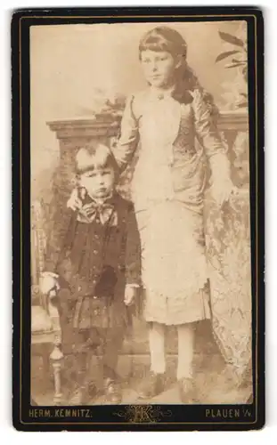 Fotografie Herm. Kemnitz, Plauen i. V., Reichsstrasse, hübsches Mädchen mit kleiner Schwester im Foto-Atelier