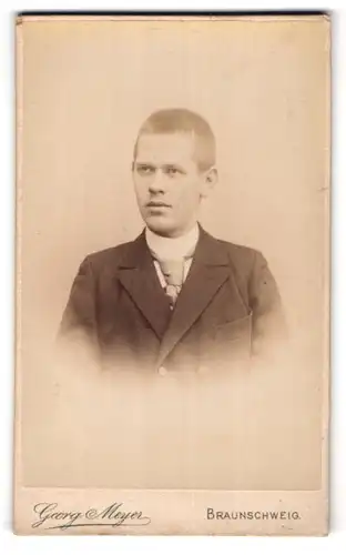 Fotografie Georg Meyer, Braunschweig, Bankplatz 3, Junger Mann mit kurzem Bürstenschnitt in Anzug und Krawatte