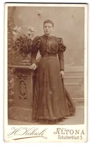 Fotografie H. Kekuli, Altona, Schulterblatt 3, Junge Frau in langem taillierten Kleid mit weitem Rock