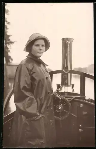 Fotografie Frau in Ölzeug als Steuermann auf einer Dampfbarkasse