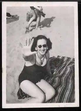 Fotografie Brünette Frau im Badeanzug am Strand liegend