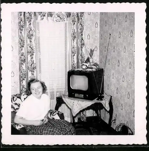 Fotografie Hausfrau neben TV-Gerät Fernseher im Sessel sitzend