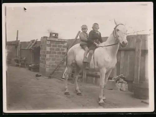 Fotografie Knaben reiten gemeinsam auf einem Pferd