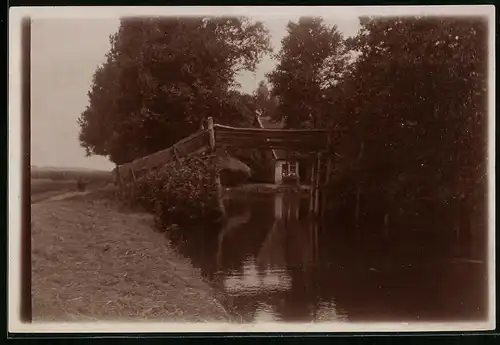 Fotografie unbekannter Fotograf, Ansicht Spreewald, Flusslauf mit Brücke am Rand einer Ortschaft im Spreewald