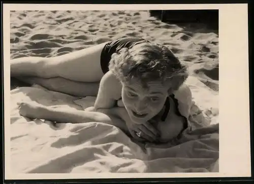 Fotografie Bademode, blonde Frau im Badeanzug am Strand liegend