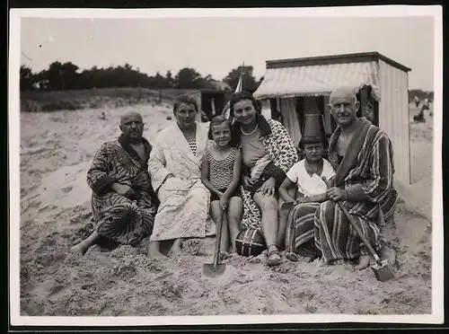 Fotografie Strandbad, Familie in Badebekleidung vor Strandkorb sitzend