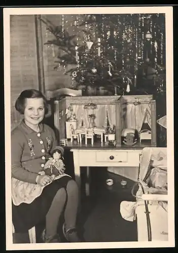 Fotografie Weihnachten, glückliches Mädchen mit Puppe & Puppenstube vor dem Weihnachtsbaum