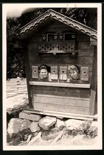 Fotografie Frauen schauen durch die Fenster einer kleinen Hütte