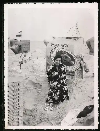 Fotografie Dame mit japanischem Schirm im Bademantel hinter Strandkorb sitzend