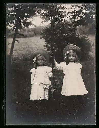 Fotografie Mädchen im Sommerkleid mit Hut tragen das gleiche Outfit