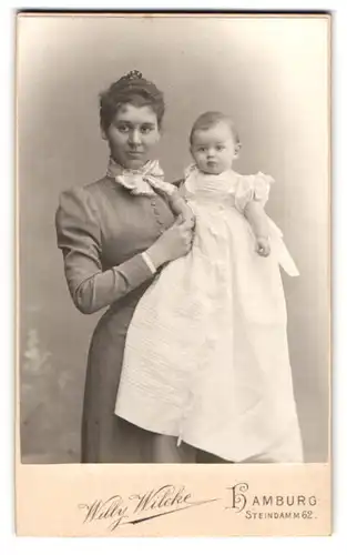 Fotografie Willy Wilcke, Hamburg, Steindamm 62, Portrait junge Mutter mit ihrem Kinde auf dem Arm, Mutterglück