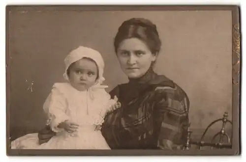 Fotografie Emil Schröterm Jüterbog, Portrait Mutter im karierten Kleid mit ihrer Tochter auf dem Schoss, Mutterglück