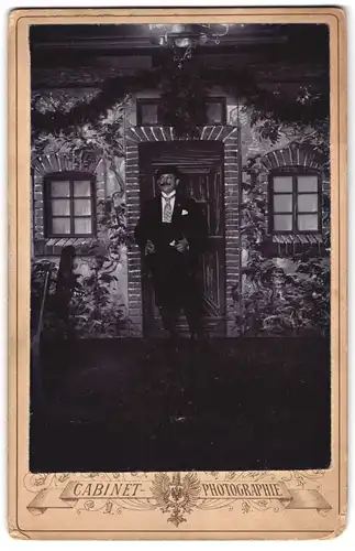 Fotografie unbekannter Fotograf und Ort, Portrait Herr im Anzug posiert vor einer Studiokulisse