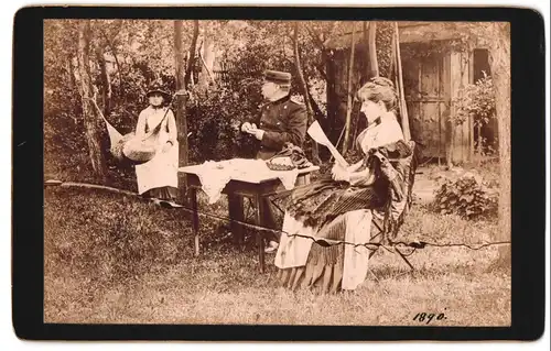 Fotografie unbekannter Fotograf und Ort, Soldat in Uniform sitzt mit Frau und Tochter im Garten, Schnupftabakdose