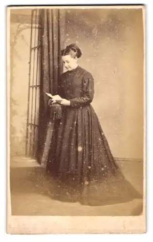 Fotografie Stuart Brothers, London, 47 Bromton Raod, junge Frau im schwarzen Kleid steht lesend im Atelier