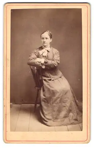 Fotografie unbekannter Fotograf und Ort, Portrait Dame im Biedermeierkleid posiert züchtig im Atelier