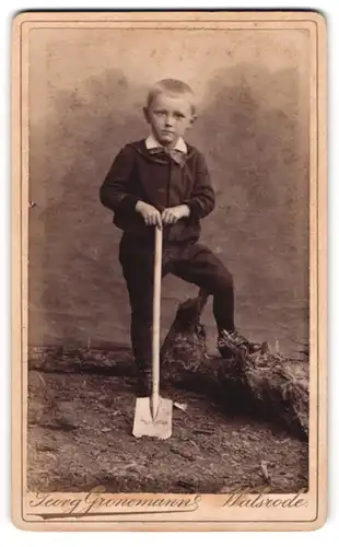Fotografie Georg Gronemanns, Walsrode, Portrait junger Knabe posiert als Gärntner mit Spaten im Atelier