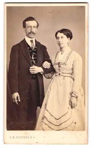 Fotografie G. B. Scuitto & C., Genova, Portrait italienisches Paar im Biedermeierkleid und Anzug mit Moustache