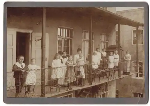 Fotografie unbekannter Fotograf und Ort, Kinder, Frauen & Dienstmagd am Haus auf einem provisorischem Balkon