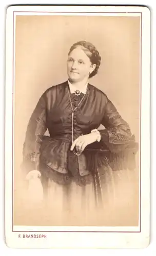 Fotografie F. Brandseph, Stuttgart, Marienstr. 36, Portrait charmant lächelnde Frau mit Flechtdutt