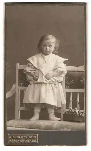 Fotografie Atelier Wertheim, Berlin, Oranienstr., Portrait süsses blondes Mädchen steht auf einer Sitzbank