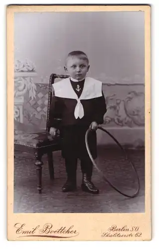 Fotografie Emil Boettcher, Berlin, Skalitzerstr. 62, Portrait frecher Bube mit Reifen im Matrosenanzug