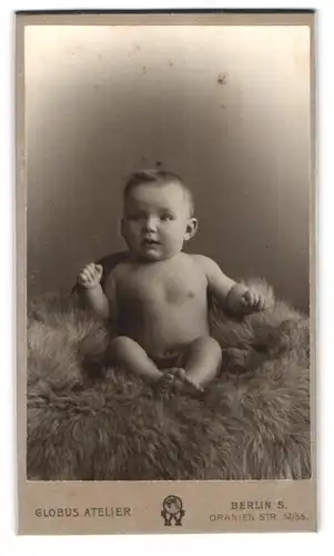 Fotografie Atelier Globus, Berlin, Oranienstr. 52 /55, Portrait nacktes Baby sitzt auf einem Fell