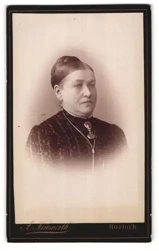 Fotografie A. Neuwerth, Rostock, Eselföter-Str. 28, Portrait einer elegant gekleideten Frau mit Brosche am Blusenkragen