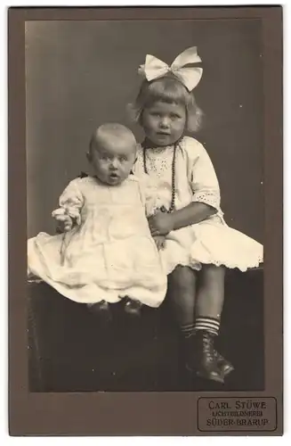 Fotografie Carl Stüwe, Süder-Brarup, Kleines Mädchen mit Haarschleife und Täufling
