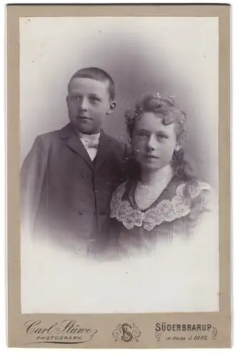 Fotografie Carl Stüwe, Süderbrarup, Knabe im Anzug mit jungem Mädchen mit lockigen Haaren
