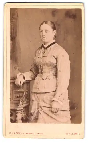 Fotografie G. J. Koch, Schleswig, Lollfuss 118-120, Junge Frau in tailliertem Kostüm mit Medaillon am Band