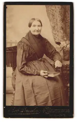 Fotografie R. Dressler, Berlin-Charlottenburg, Schloss-Str. 15, Ältere Dame mit Schultertuch und Buch in der Hand
