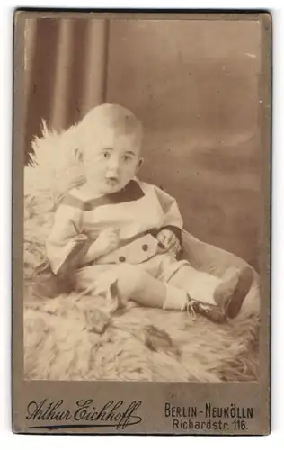 Fotografie Arthur Eichhoff, Berlin-Neukölln, Richardstr. 116, Kleinkind in modischer Kleidung sitzt auf Fell