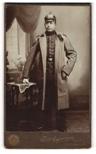 Fotografie J. Assmann, Thorn, Portrait junger Soldat in Uniform mit Mantel und Pickelhaube