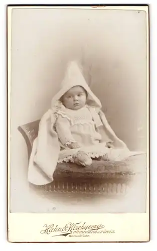 Fotografie Hahn & Kirchgeorg, Nürnberg, Portrait süsses Kleinkind im Strickkleid mit Zipfelmützendecke im Atelier