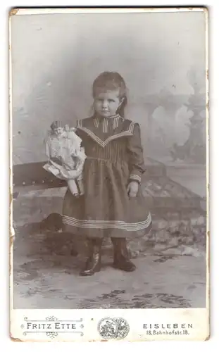 Fotografie Friz Ette, Eisleben, Bahnhofstr. 18, kleines Mädchen im Kleidchen mit ihrer Puppe im Arm