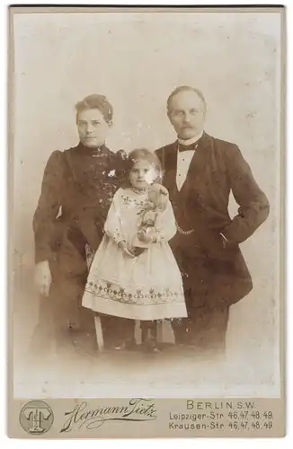 Fotografie Hermann Tietz, Berlin, Leipzigerstr., Portrait Eltern mit ihrer Tochter samt Puppe im Atelier