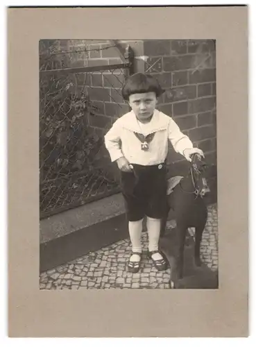 Fotografie unbekannter Fotograf und Ort, Portrait kleines Kind in Samthose mit Schaukelpferd