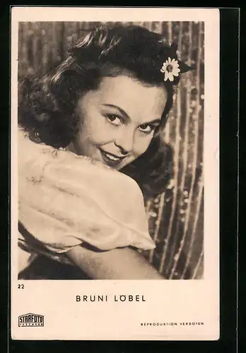 AK Schauspielerin Bruni Löbel lächelt mit einer Blume im Haar