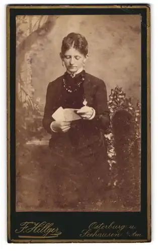 Fotografie F. Hillger, Osterburg, junge Frau im dunklen Biedermeierkleid liest einen Brief im Atelier