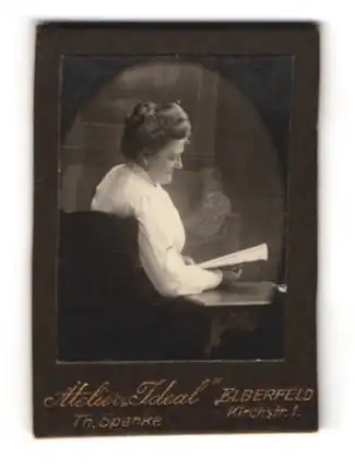 Fotografie Atelier Ideal, Elberfeld, Kirchstr. 1, Dame in weisser Bluse liest ein Heft im Atelier, Rückenportrait