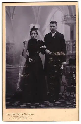Fotografie Fritz Hckaer, Annaberg, Carlsplatz 3, Portrait junges Brautpaar im schwarzen Kleid und Anzug, Schleier