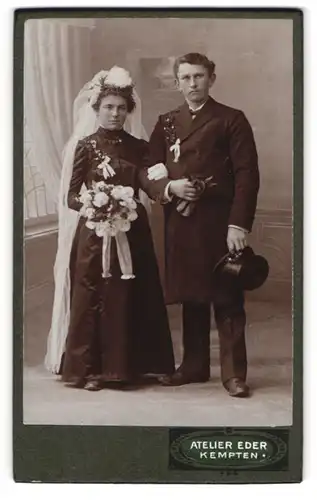 Fotografie Atelier Eder, Kempten, Brautpaar im schwarzen Hochzeitskleid und Anzug mit Schleifen