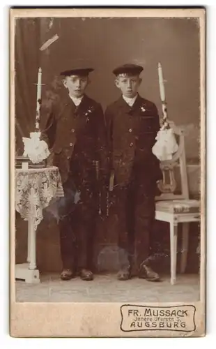 Fotografie Fr. Mussack, Augsburg, zwei junge Knaben in Anzügen mit langen Kommunionskerzen in der Hand