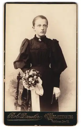 Fotografie Rob. Dressler, Charlottenburg, Schloss-Str. 15, junges Mädchen im schwarzen Kleid zur Kommunion mit Blumen