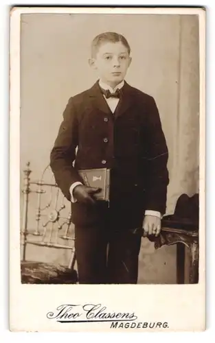 Fotografie Theo Classens, Magdeburg, Fürstenstr., Portrait Knabe Franz Bohne im Anzug mit Lederhandschuh und Bibel
