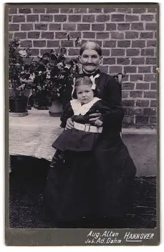 Fotografie Aug. Alten, Hannover, Ältere Dame im Kleid mit kleinem Mädchen auf dem Schoss