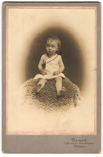 Fotografie Doisen, Paris, 123, Bould. Sébastopol, Kleines Mädchen im Hemd sitzt auf Fell