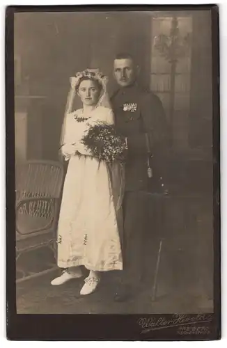 Fotografie Walter Herold, Freiberg, Fischerstr., Uffz in Uniform mit Ordenspange nebst Braut, Kriegshochzeit